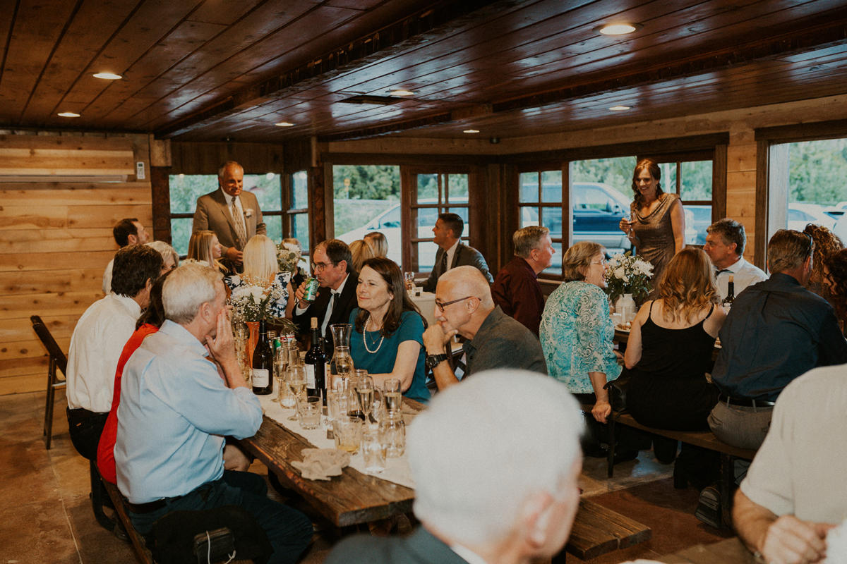 Guests at long wooden tables inside the timber-lined lodge